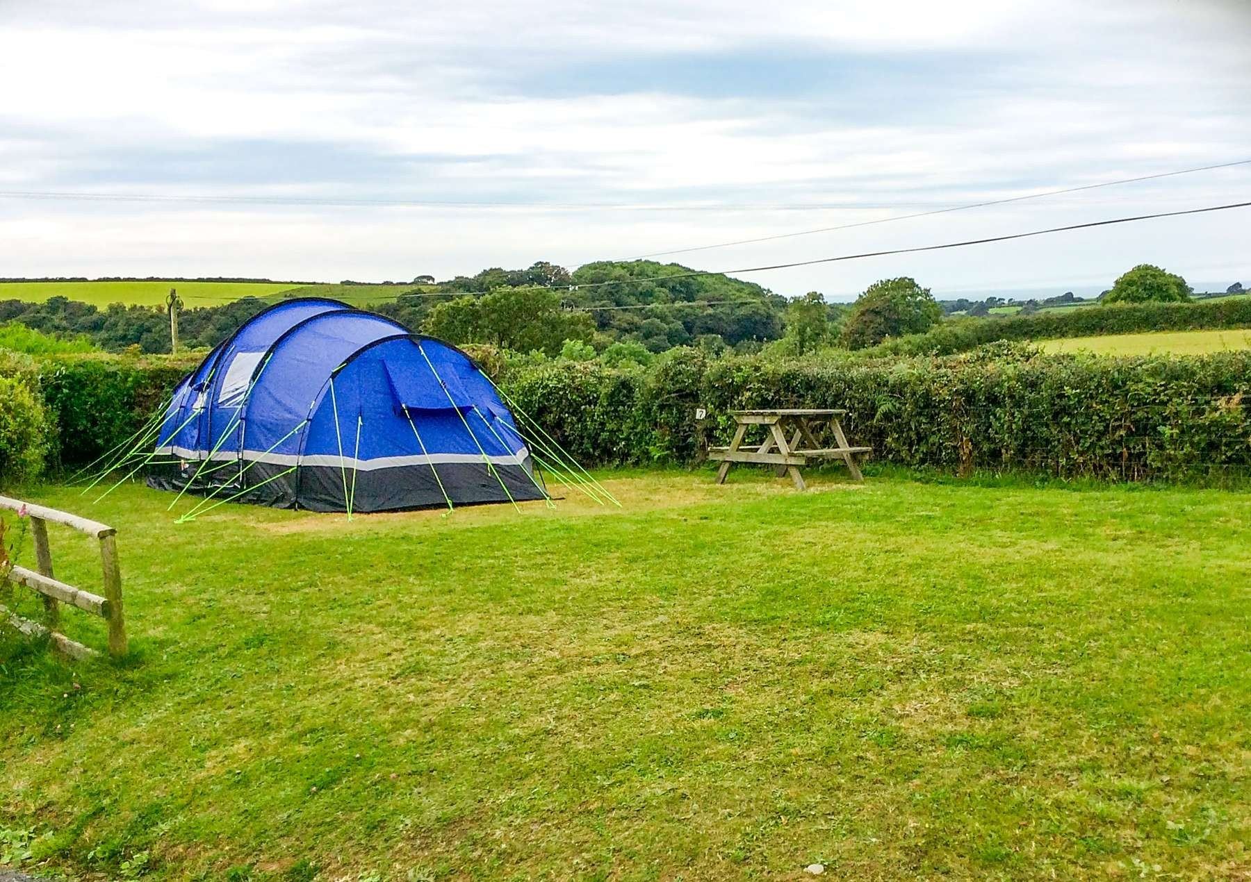 A tent pitched on level grass at Gwaun Vale with a picnic bench